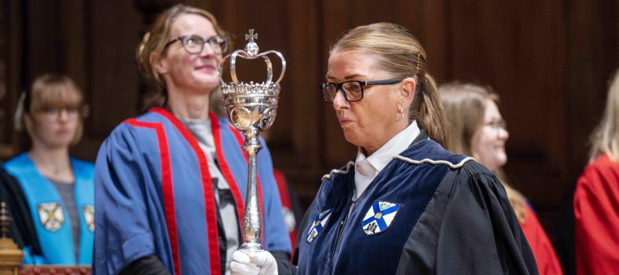 A bedellus holding the university mace.